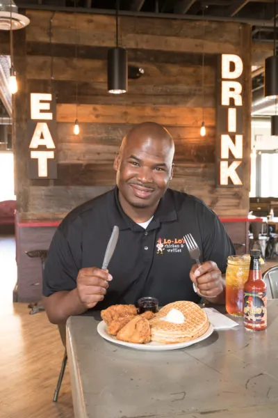 Larry White Jr. enjoys a plate of chicken and waffles from Lo-Lo’s Chicken and Waffles.