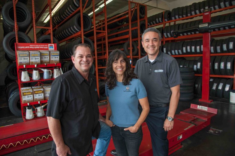 Becker Tire owners Stuart Hecker (L) and Jason Berry flank Stacey Sanchez, senior loan officer with CDC Small Business Finance