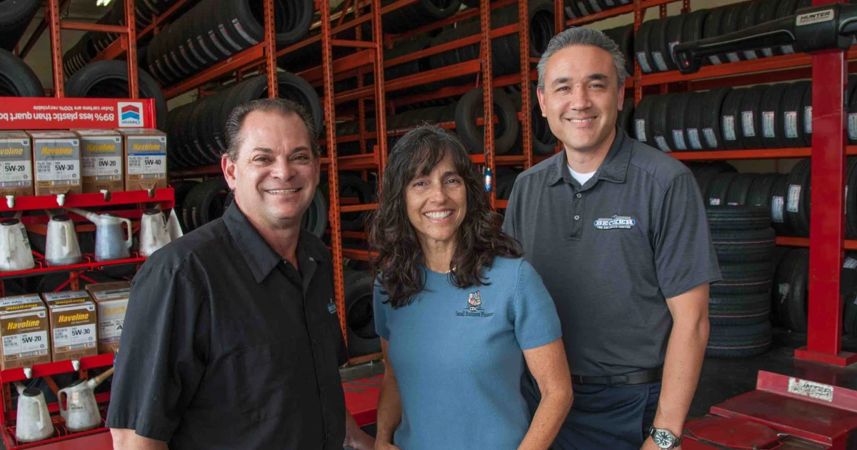 Becker Tire owners Stuart Hecker (L) and Jason Berry flank Stacey Sanchez, senior loan officer with CDC Small Business Finance.