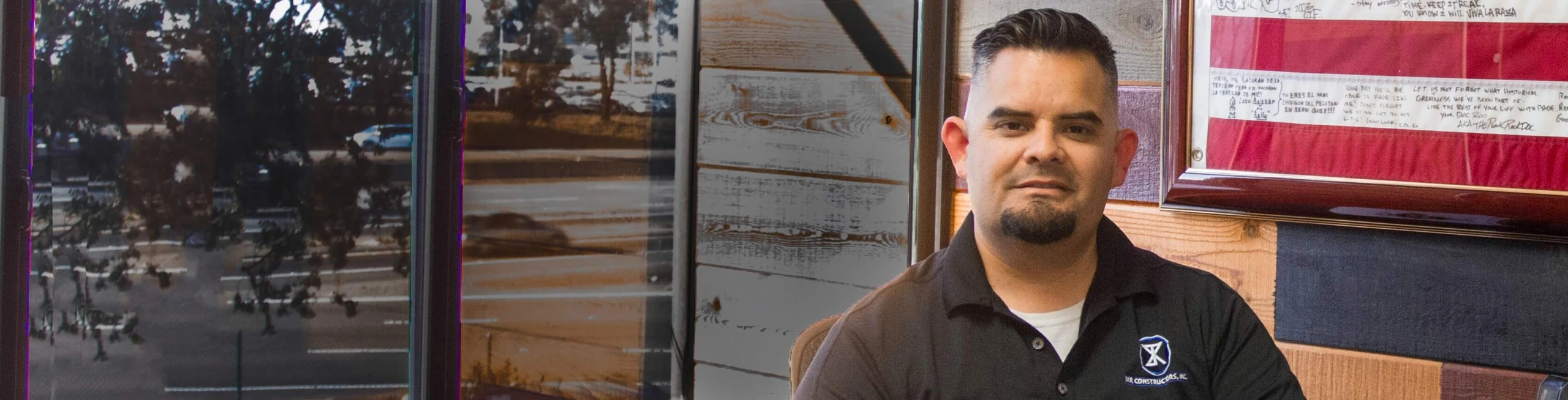 A military entrepreneur who worked with CDC Small Business Finance to help grow his business poses in front of a wall featuring the American Flag.