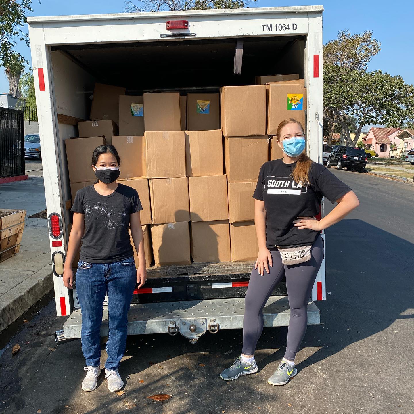 Two women stand in front of a truck loaded with food boxes from South L.A. Cafe, a business which received financing from CDC Small Business Finance.