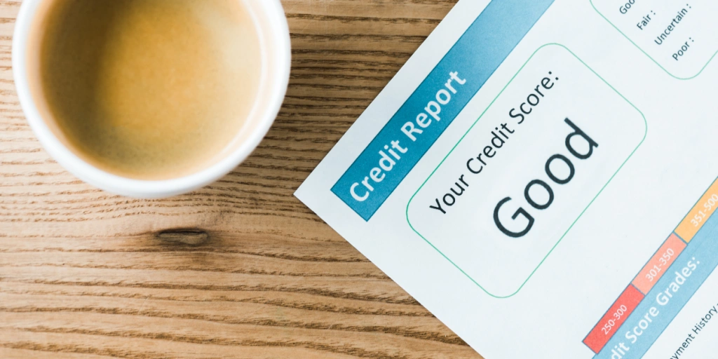 Image of table with credit report and a coffee, the credit report is good, but it's good to know how to remove negative items from credit report