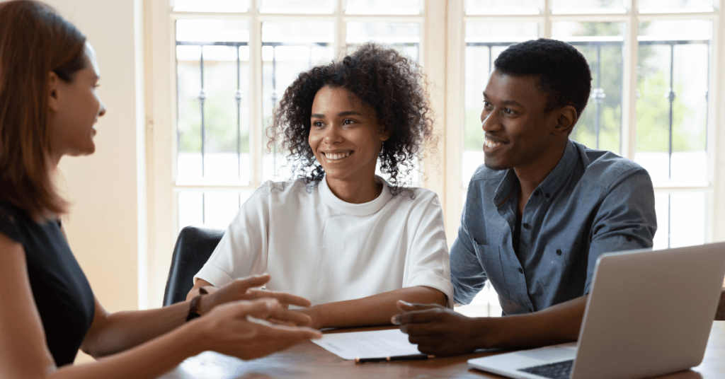 A photo of a man and woman completing a real estate deal with an agent.