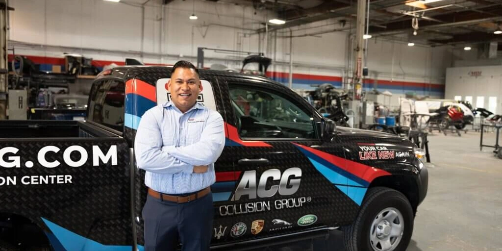 Small business owner stands in his auto repair shop after obtaining an SBA 504 commercial real estate loan in Santa Ana California.