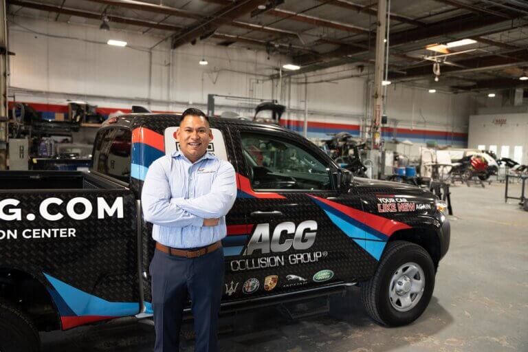 Latino small business owner stands in his auto repair shop after obtaining an SBA 504 commercial real estate loan in Santa Ana California.