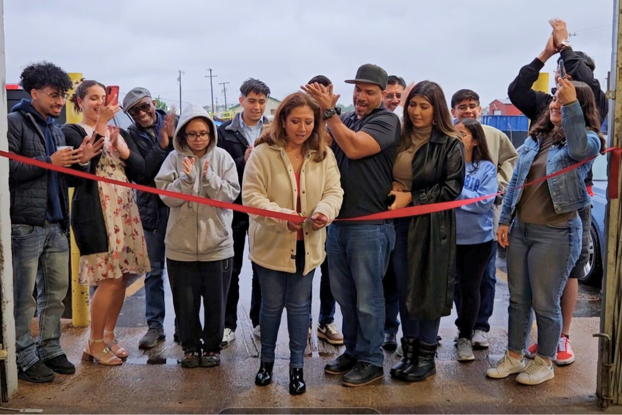 Several people participate in OYE's small business success at a ribbon-cutting ceremony to inaugurate the new warehouse facility.