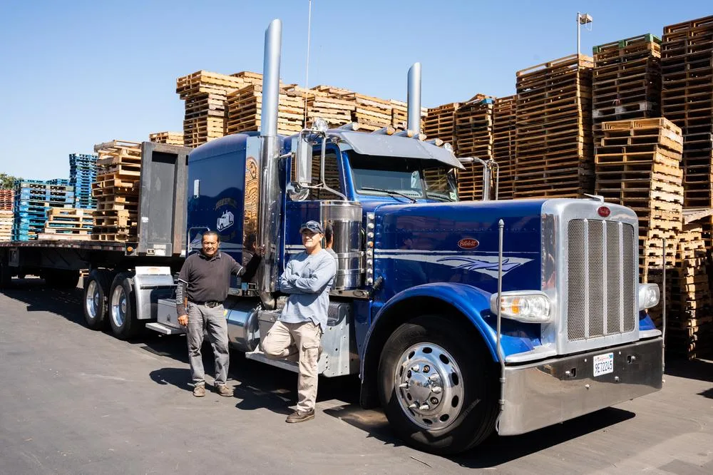 Juan and Juan Jr. in front of a blue semi which was purchased with the help of small business financing.