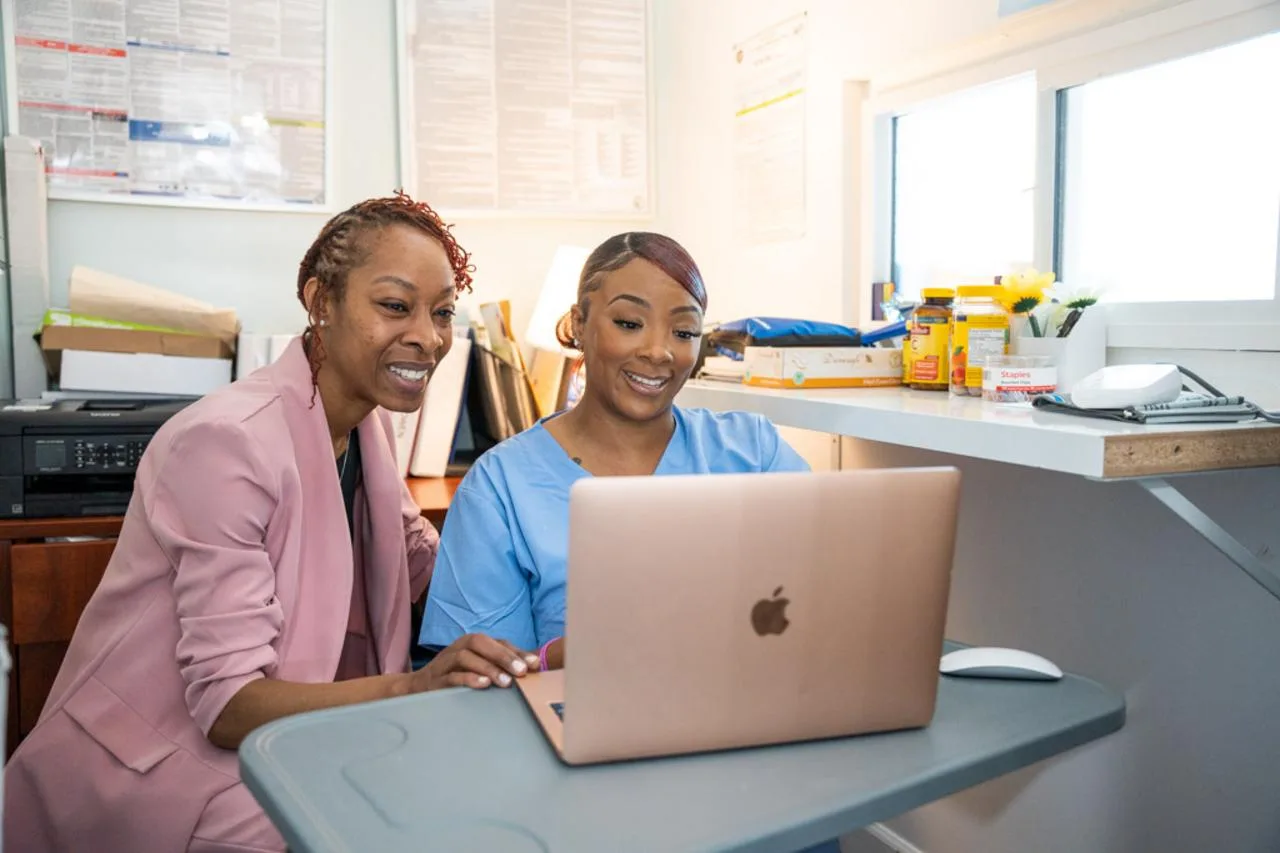 Maximize new rates featured image, Loan officer and borrower look at a computer and smile at new lower rates!