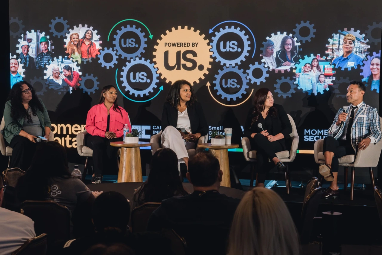 Four women and one man sit for a panel discussion around accessing capital despite barriers