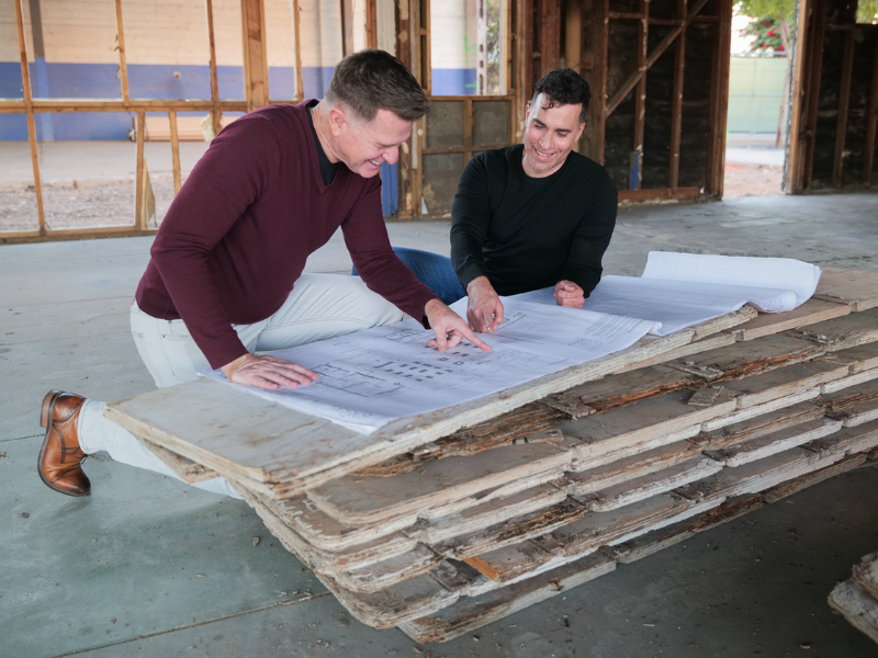 Borrowers looking over the blueprints at a new location made possible with SBA loans.
