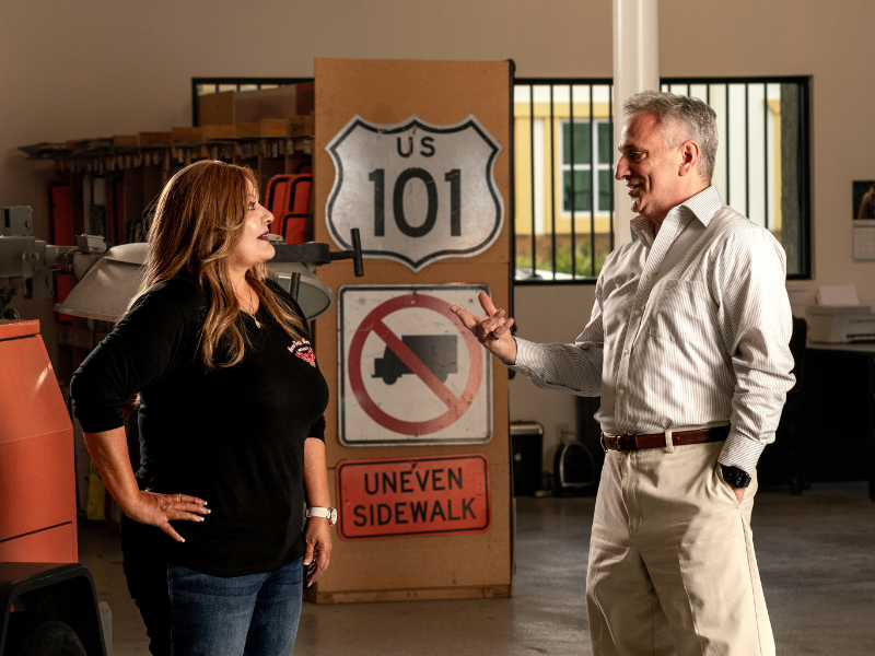 10% start-up injections are back. Our loan experts are ready. Image of a loan expert helping a borrower in her warehouse facility.